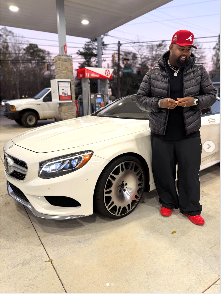 Bruce Webb standing next to his white Mercedes at a gas station