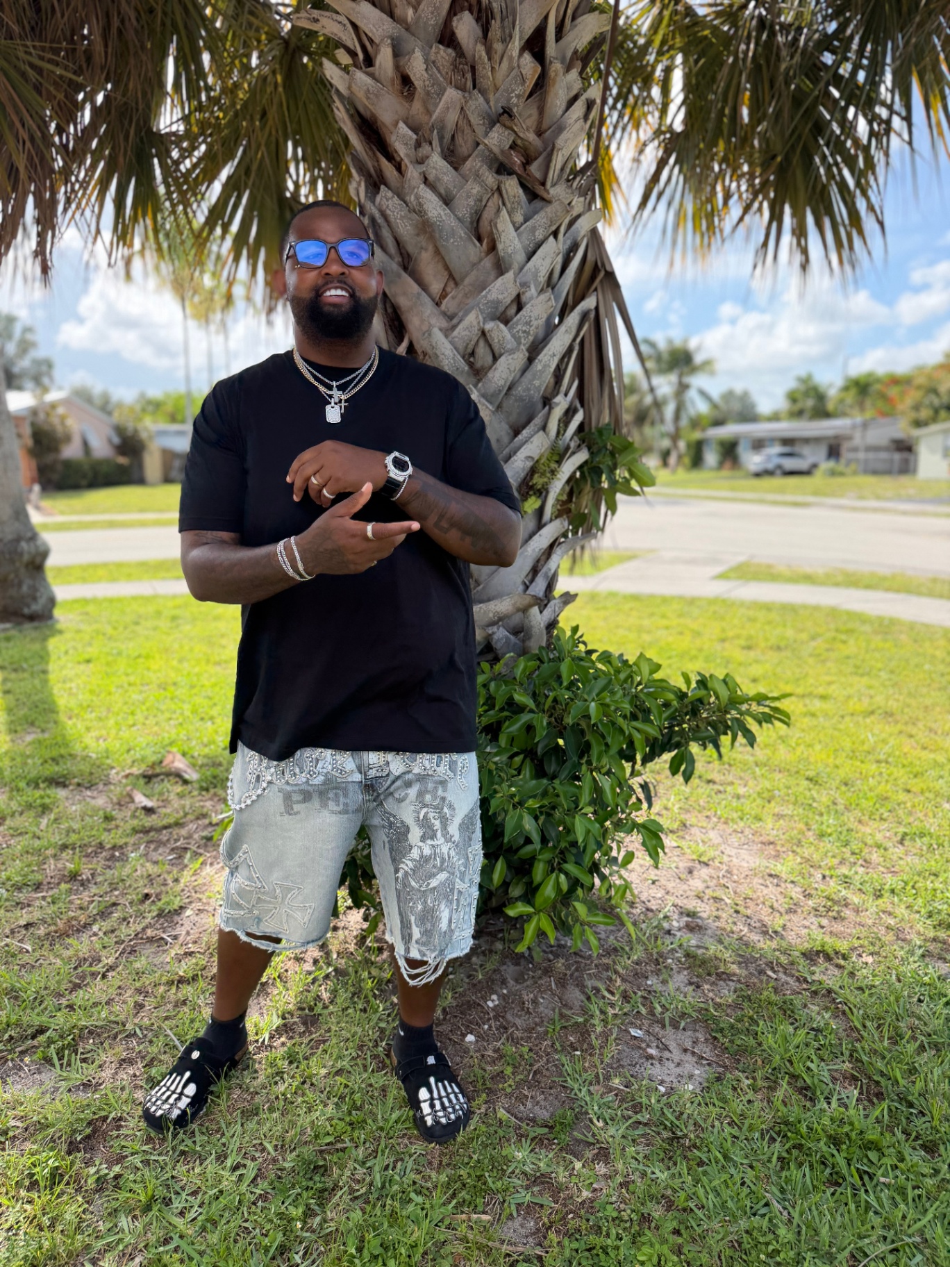 Bruce Webb under a palm tree iced out in chains